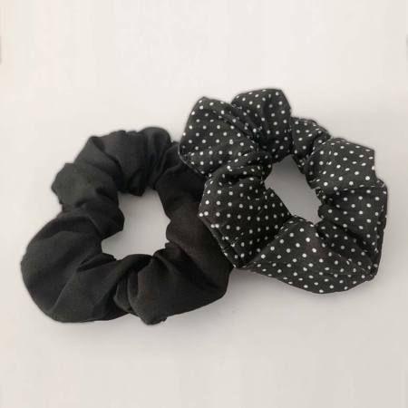 Product photo: Two lice deterrent fabric hair scrunchies, in plain black and black with white polkadots